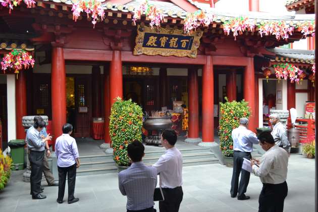 Businessmen chatting in the forecourt of the oldest Buddhist temple in Singapore